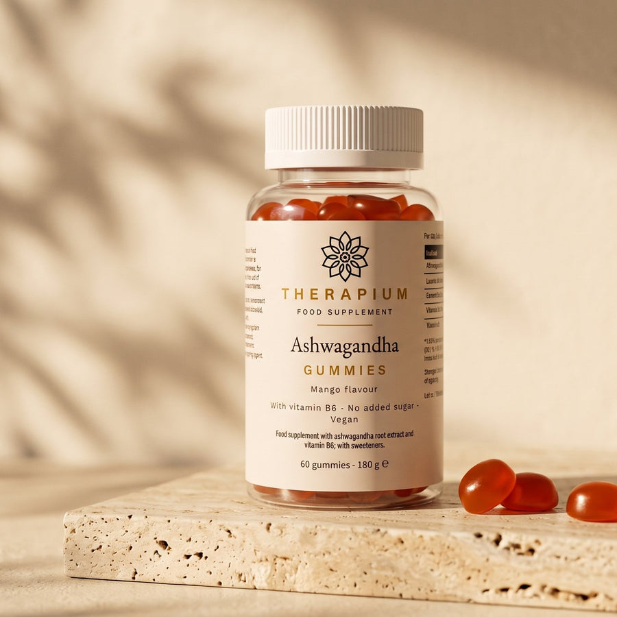 Therapium Ashwagandha Gummies, the jar on a travertine ledge in morning light with three mango gummies beside it