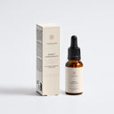 Therapium SERAVIA™ Calming Facial Oil, amber glass dropper bottle next to its carton, front view on a plain studio background