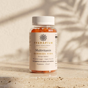 Therapium Multivitamin Gummies Kids jar standing on a travertine stone ledge in warm morning light