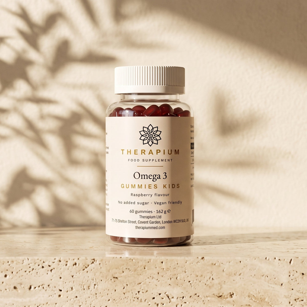 Therapium Omega 3 Gummies Kids jar standing on a travertine stone ledge in warm morning light