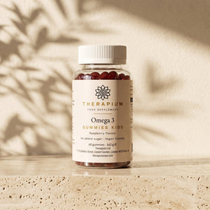 Therapium Omega 3 Gummies Kids jar standing on a travertine stone ledge in warm morning light