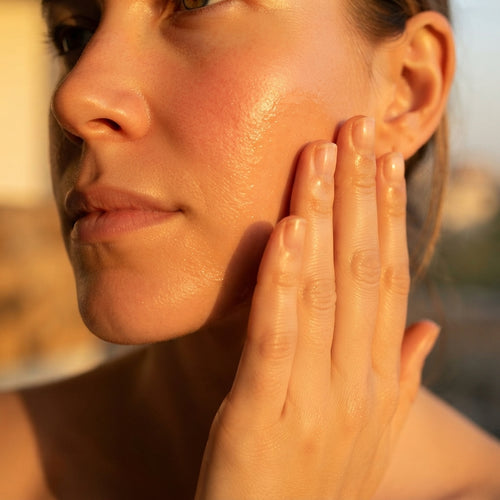 Therapium Nourishing Facial Oil being applied to the cheek in warm light