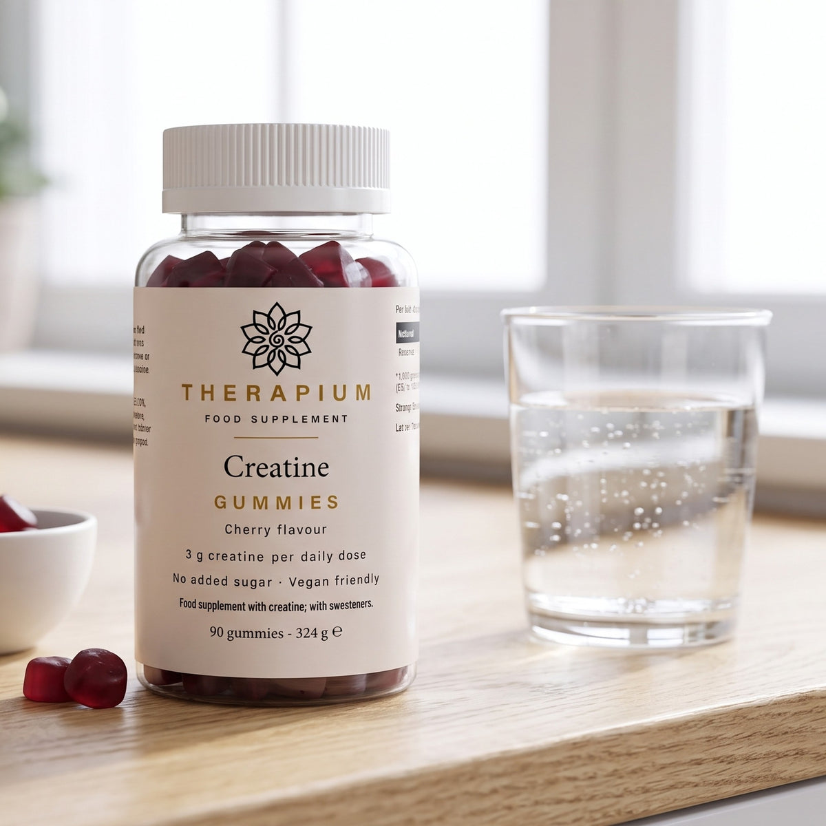 Therapium Creatine Gummies jar on a kitchen counter with a glass of water