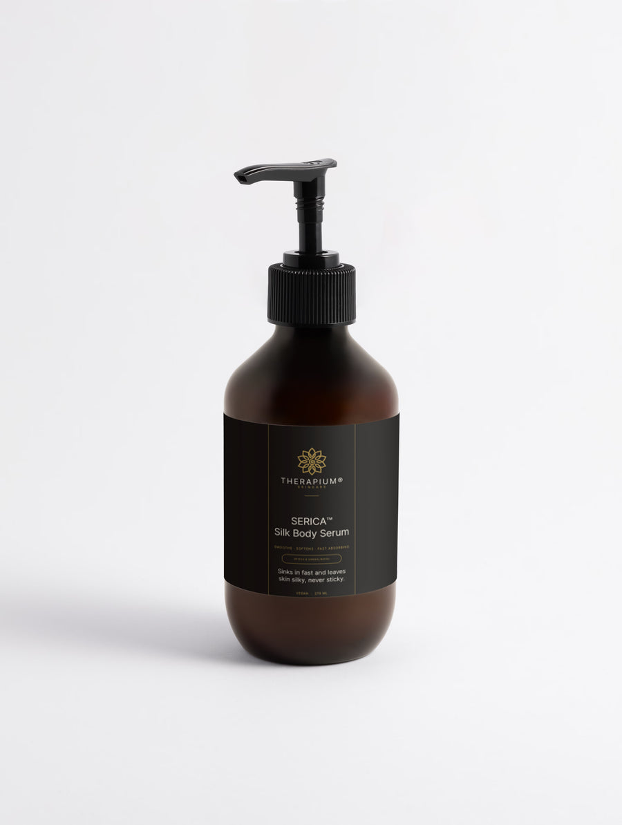 Therapium SERICA Silk Body Serum, Spices & Sandalwood, 270 ml amber pump bottle with black label, front view on a plain studio background